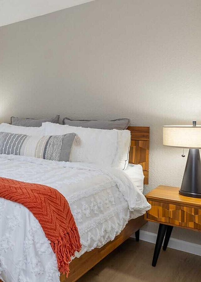 Inviting bedroom featuring modern furnishings, plush bedding, and natural light streaming through a large window.