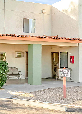 Charming leasing office with a welcoming exterior, surrounded by lush greenery and vibrant flowers.