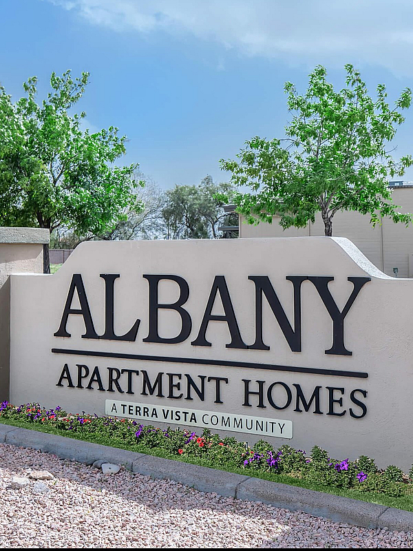 Entrance sign for Albany Apartment Homes in a beautifully landscaped community setting.