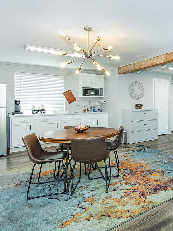 Contemporary open-concept apartment with stylish dining area, chic kitchen, and modern lighting, perfect for urban living.