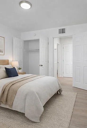 Inviting bedroom with elegant decor, featuring a plush bed, warm wooden furniture, and tasteful artwork on the walls.