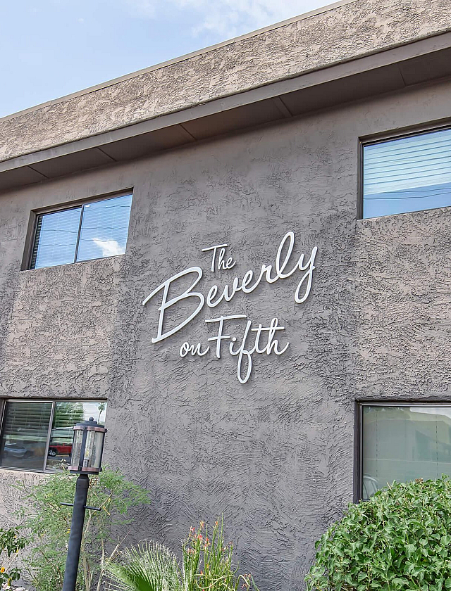 Charming exterior of The Beverly on Fifth showcasing a modern facade with lush greenery and stylish architectural design.