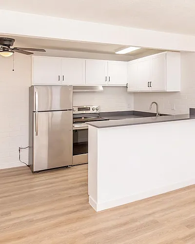 Renovated kitchen with stainless steel appliances and white cabinetry at Miramonte on 3rd, Tucson