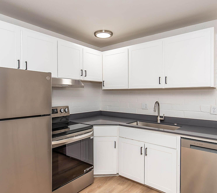 Renovated kitchen with stainless steel appliances and white cabinetry at Palms on 2nd, Tucson