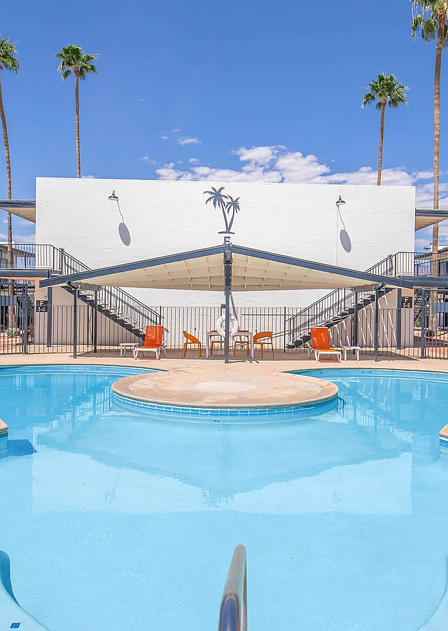 Courtyard round pool with orange loungers and shaded seating at Palms on 2nd, Tucson