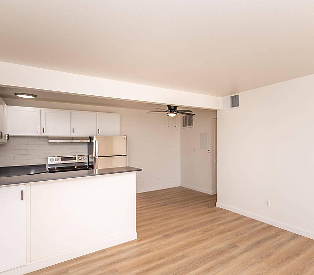 Open-concept kitchen with modern appliances and wood flooring at Palms on 2nd, Tucson