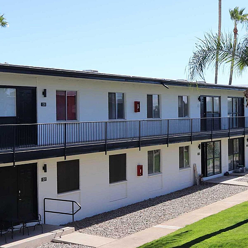 Two-story apartment buildings with green lawns and palm trees at Palms on 2nd, Tucson AZ