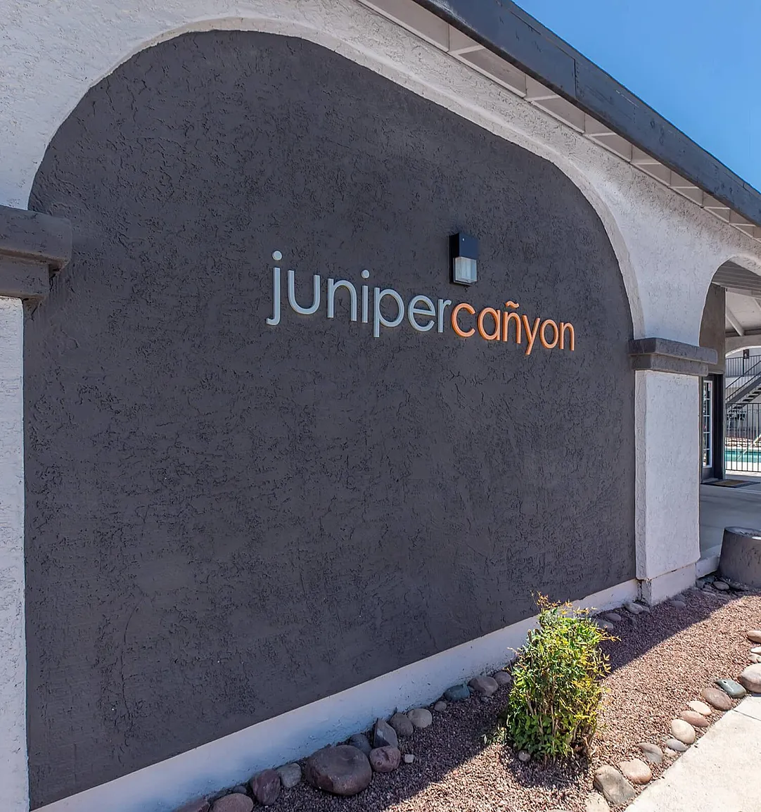 Inviting entrance of Juniper Canyon showcasing modern architecture with elegant arches and a serene landscaped path.