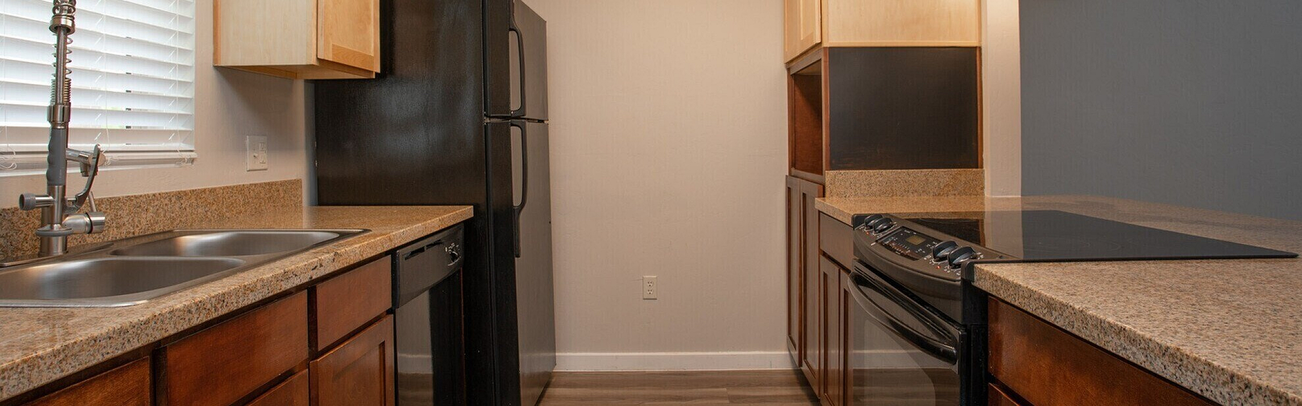 Modern kitchen with sleek countertops, rich wooden cabinets, and high-end appliances, offering a warm and inviting cooking space.
