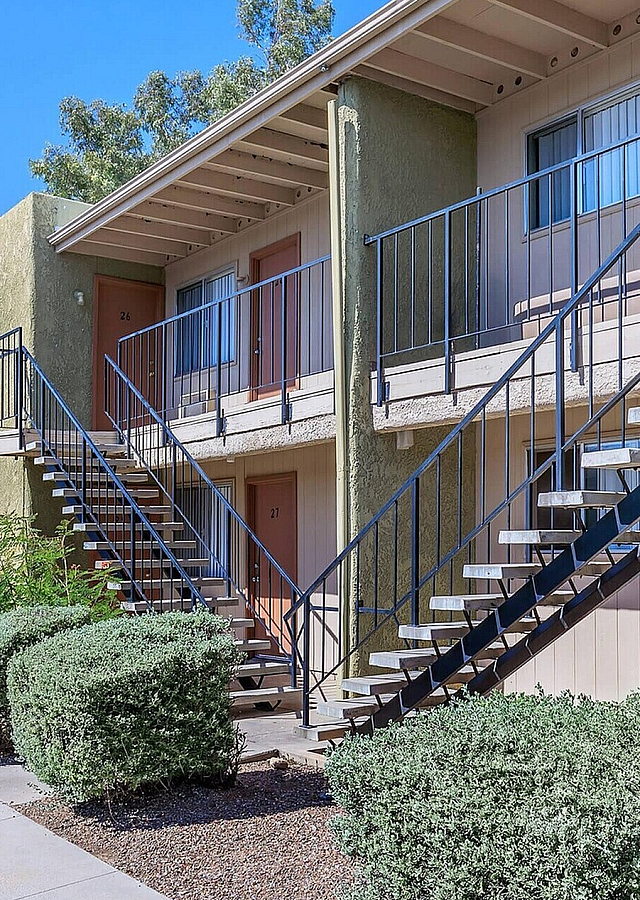 Charming two-story apartment building with modern outdoor stairs and well-maintained landscaping.