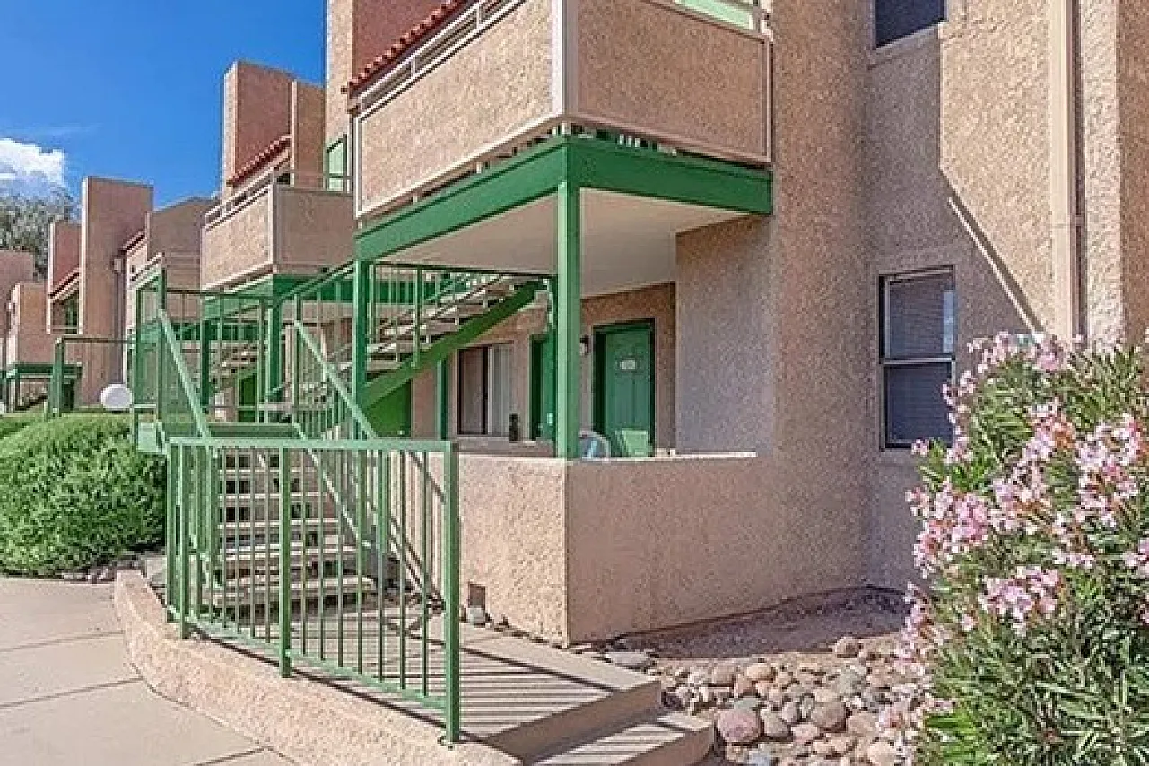 Charming apartment exterior with vibrant green accents and inviting balconies, set in a beautifully landscaped community.