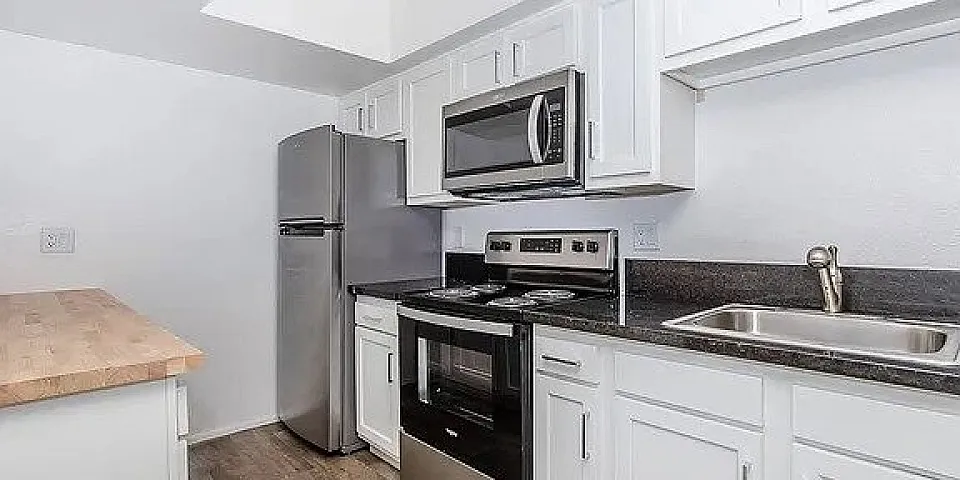 Modern kitchen with stainless steel appliances, sleek countertops, and bright cabinetry, perfect for culinary enthusiasts.