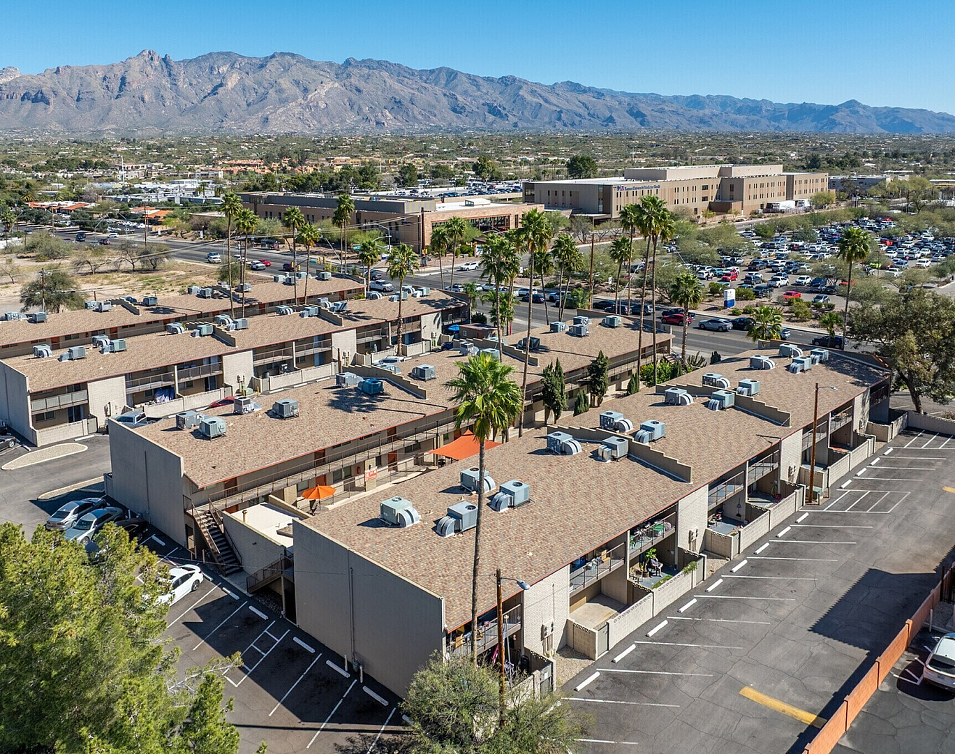 Charming apartment complex with stunning mountain views, ample parking, and vibrant greenery.