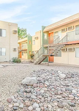 Charming apartment complex with vibrant doors, tranquil courtyard, and modern metal staircases.