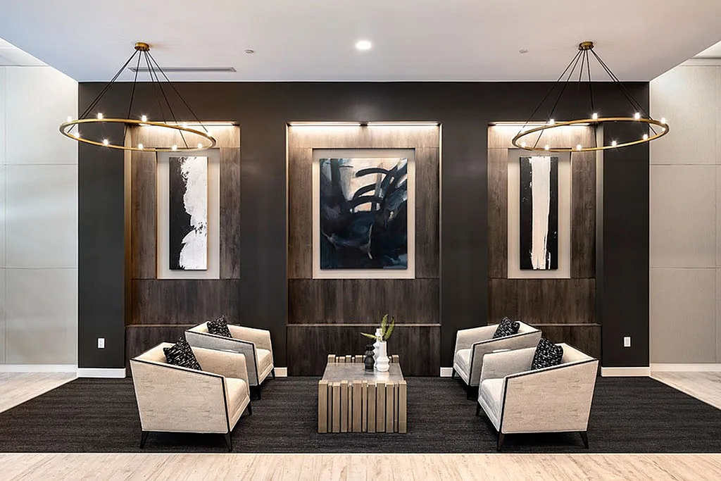 Elegant lounge area with modern armchairs, artistic wall paintings, and chic lighting, creating a sophisticated atmosphere.