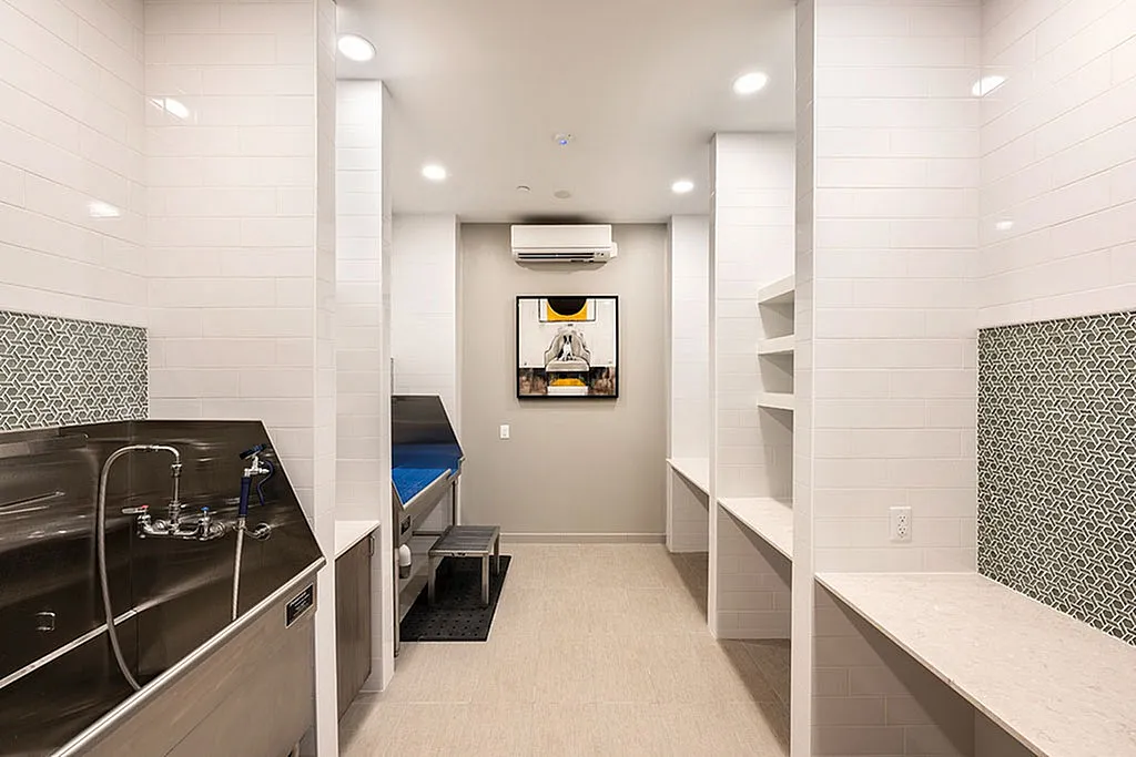 Modern apartment interior featuring a sleek utility area with stainless steel fixtures and elegant white tiled walls.