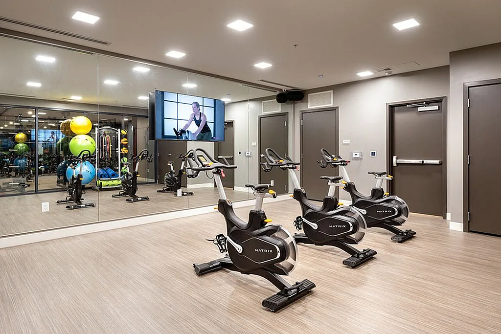 Modern gym with sleek exercise bikes, mirrored walls, and vibrant fitness equipment creating an invigorating workout environment.