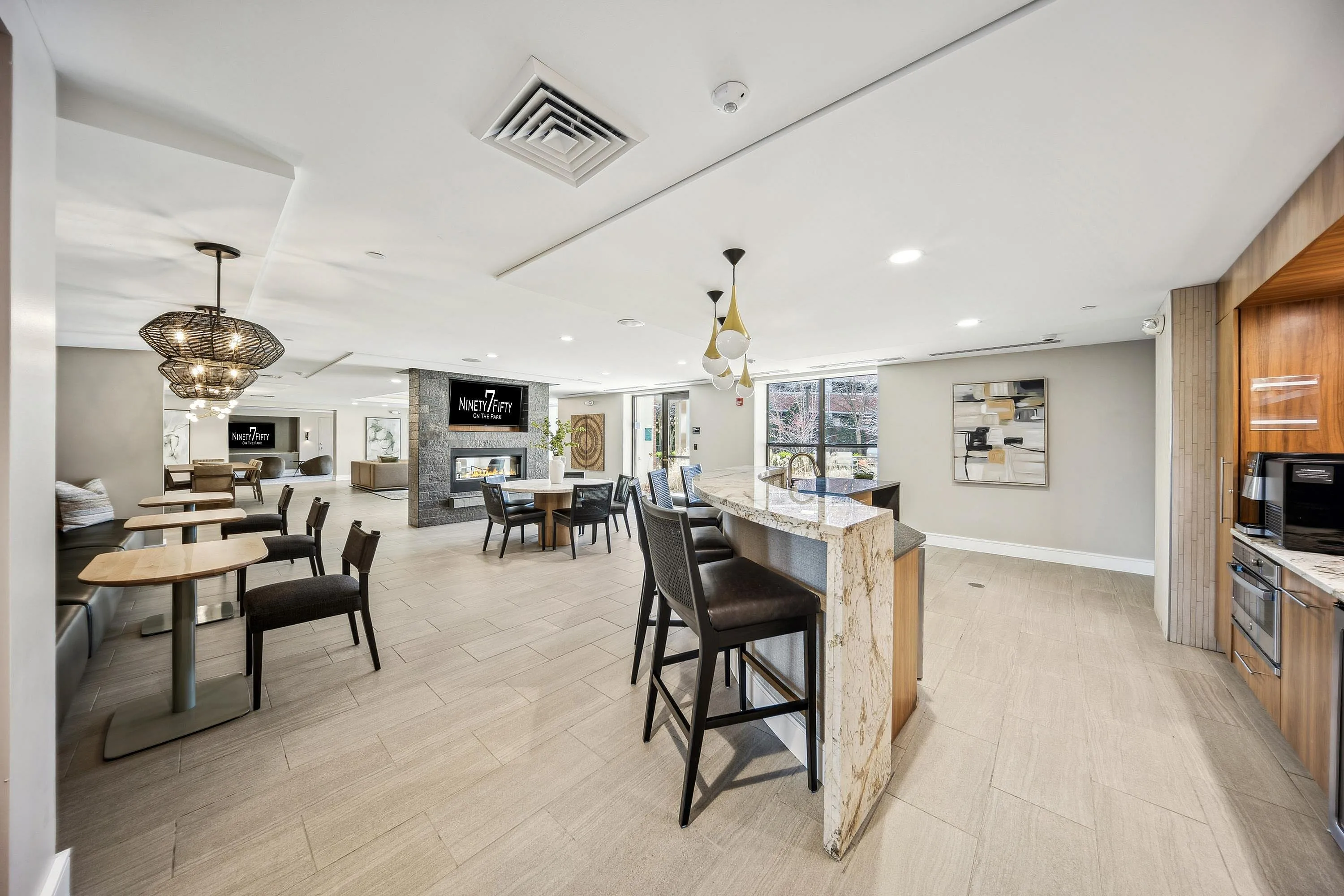 Chic and inviting communal lounge area featuring elegant seating, stylish lighting fixtures, and a cozy fireplace, perfect for relaxation and socializing.