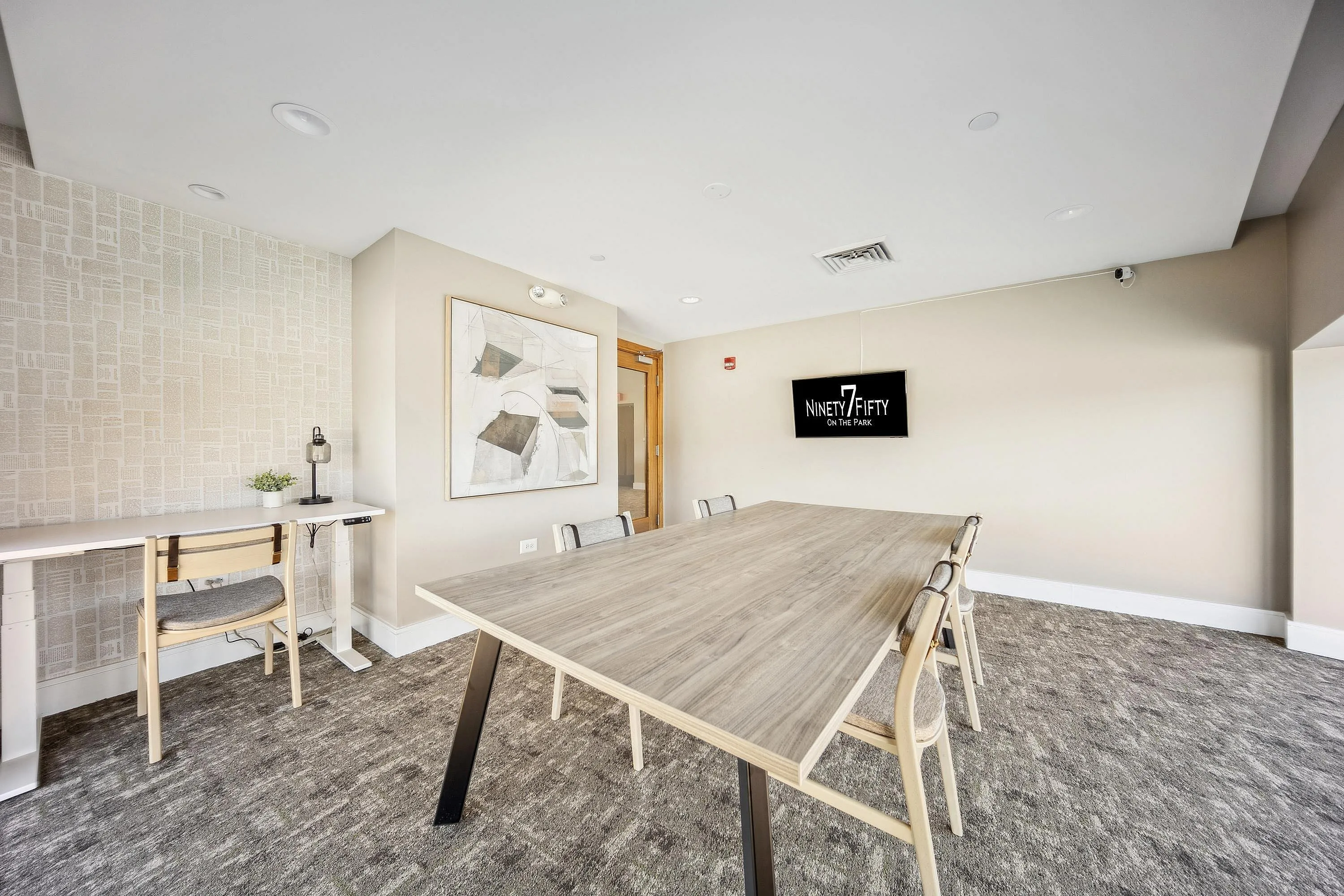 Modern conference room with a sleek wooden table, comfortable chairs, and stylish decor at Ninety7 Fifty on the Park.