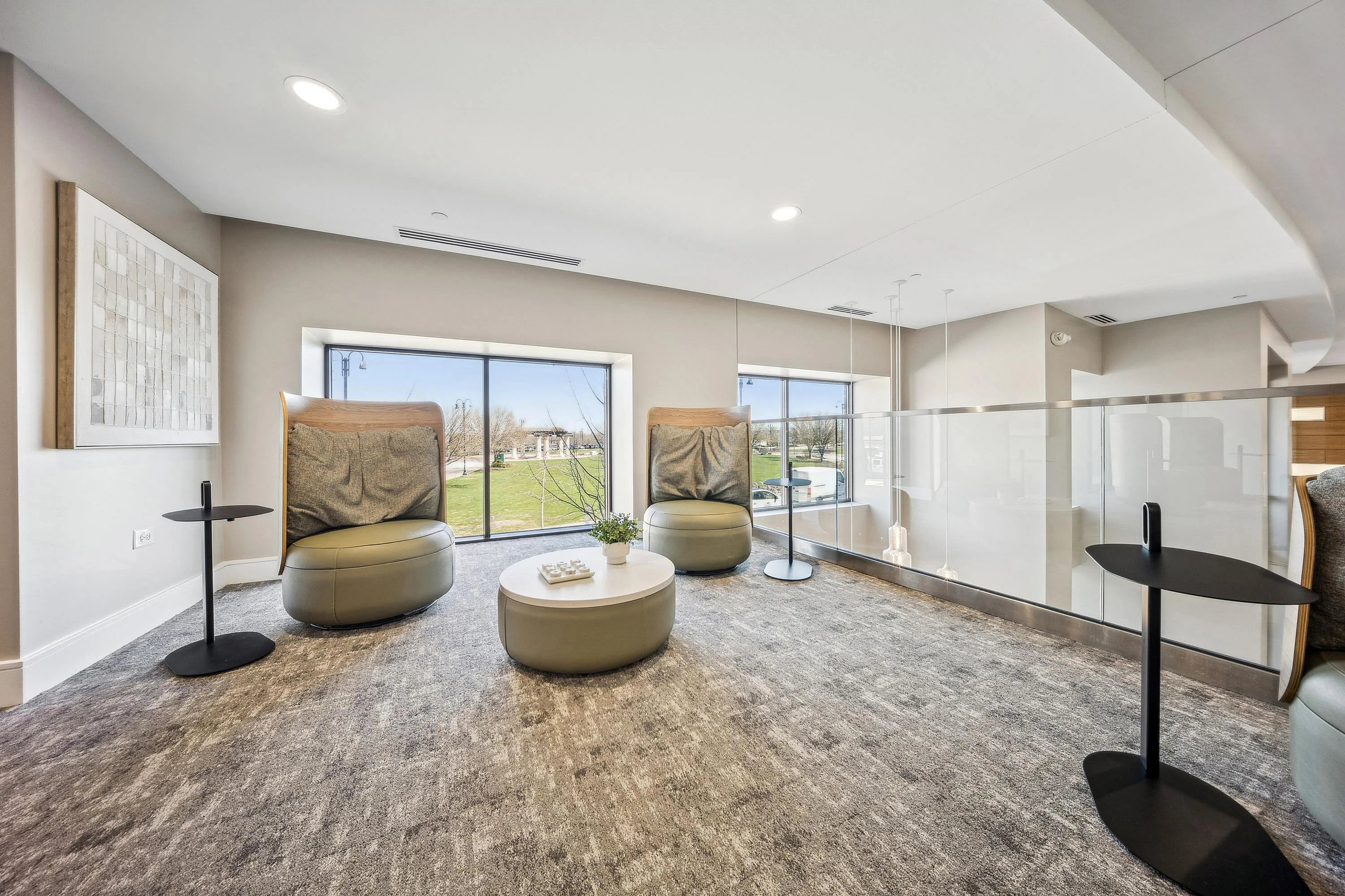Modern lounge area with plush seating, sleek tables, and large windows offering scenic outdoor views.