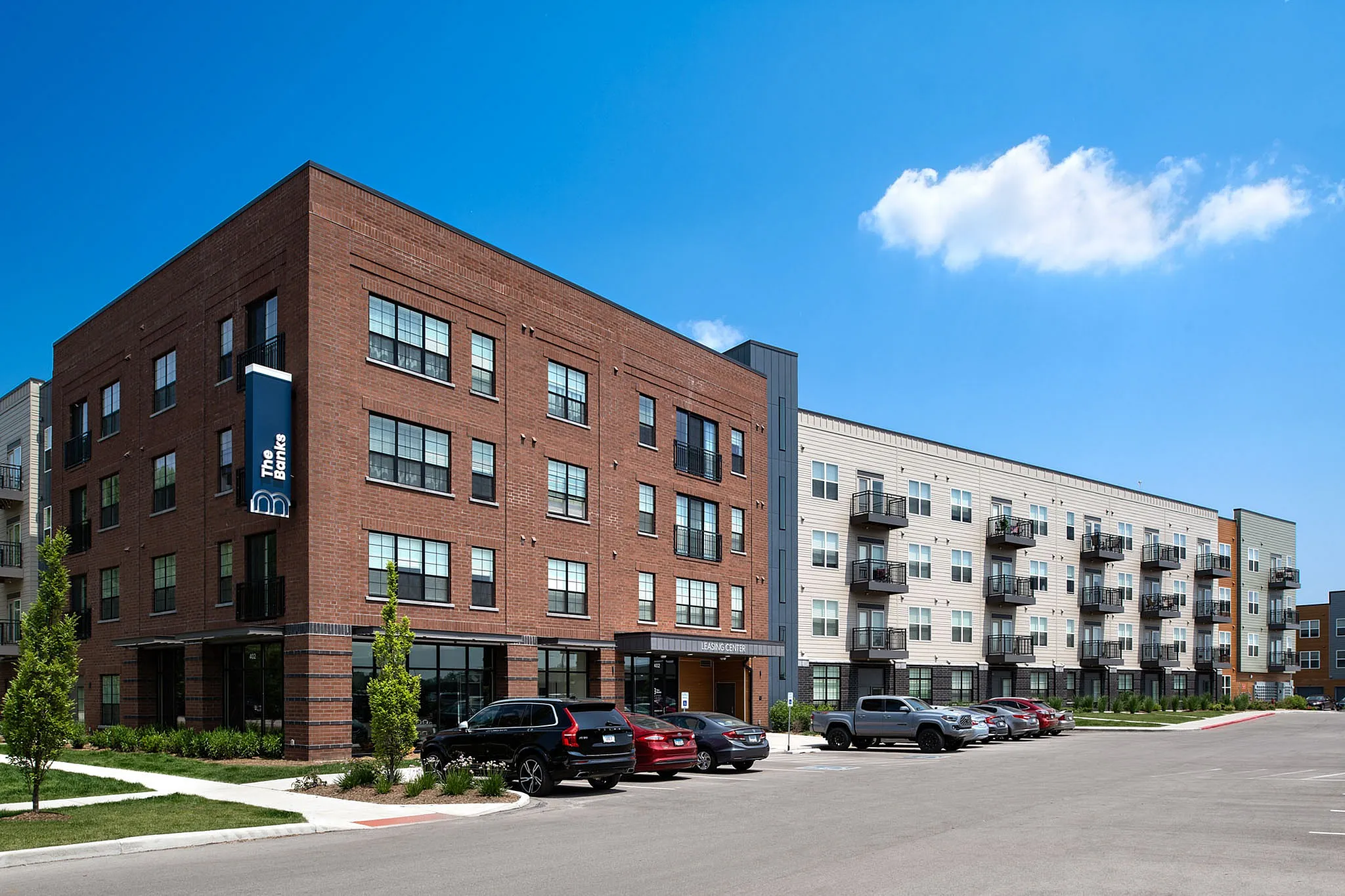 Modern apartment complex with brick facade, large windows, and balconies, offering premium urban living.