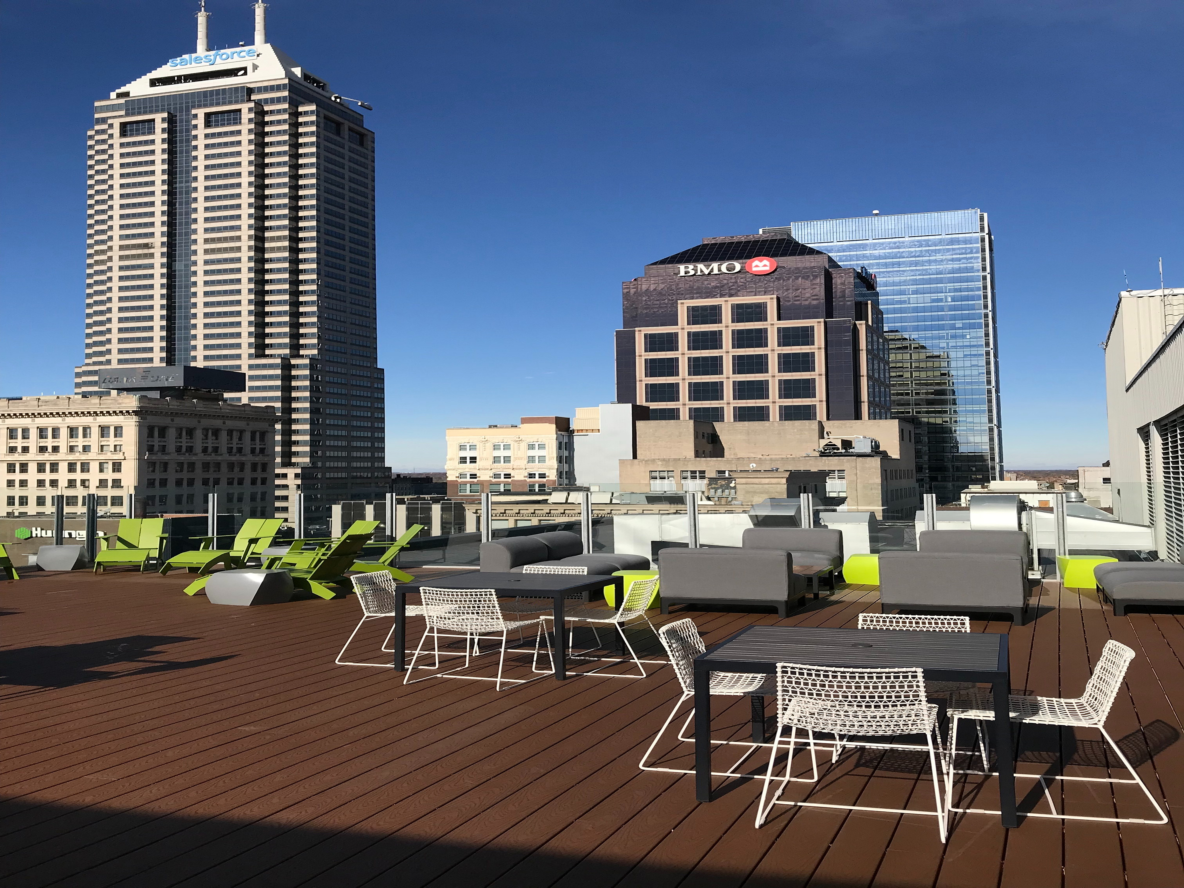 Chic rooftop terrace with stylish outdoor seating offering stunning city skyline views on a sunny day.