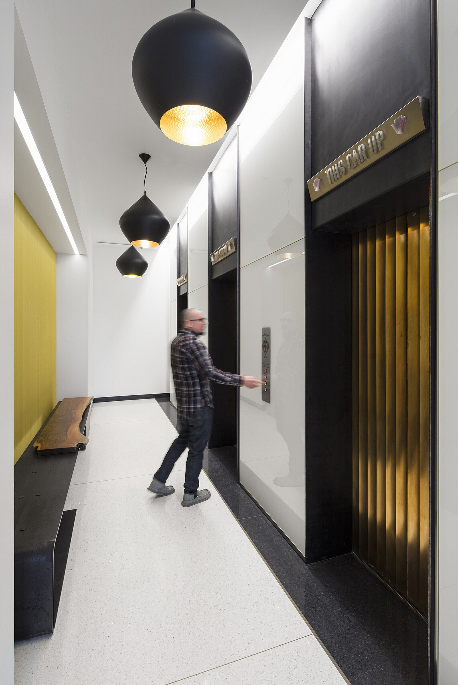 Modern hallway with sleek elevators and artistic lighting design, offering a sophisticated apartment living experience.