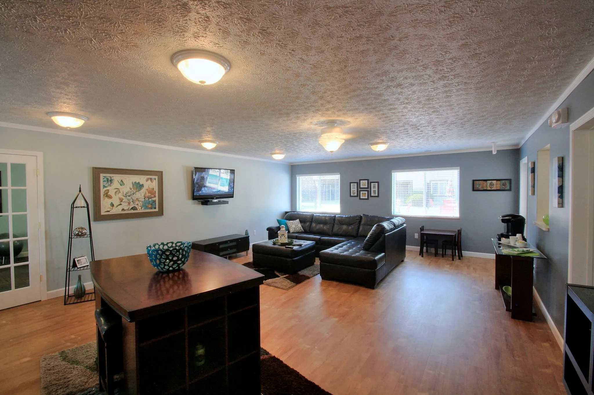 Bright and inviting living room featuring a spacious sectional sofa, hardwood floors, and modern decor, perfect for relaxation and entertainment.
