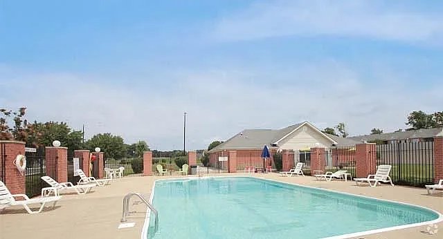 Inviting outdoor pool area with lounge chairs and lush surroundings, perfect for relaxation and leisure.