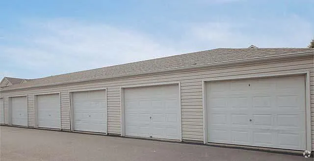 Series of modern, well-maintained garage units with white doors and a clean, paved driveway.