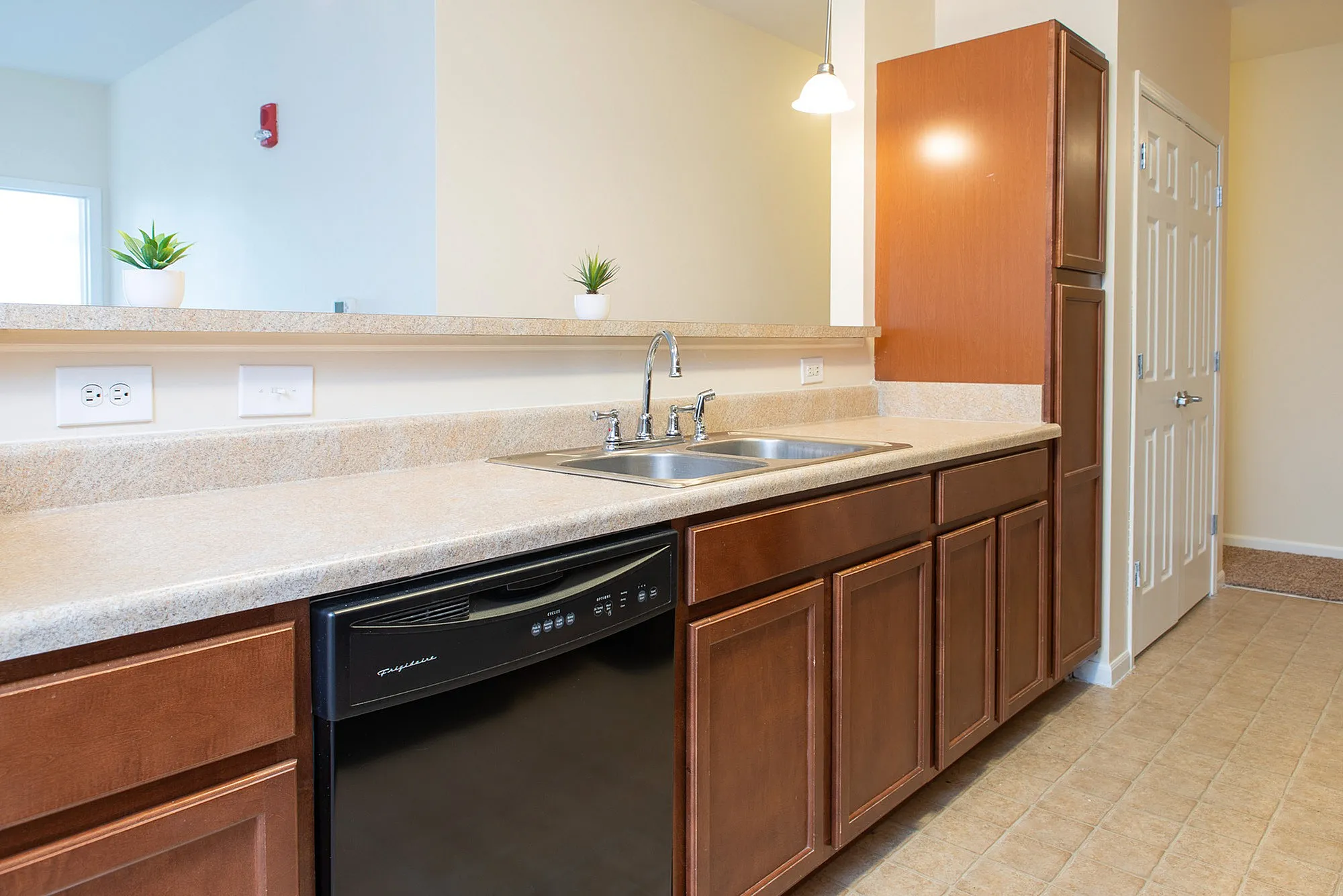 Bright and modern kitchen featuring elegant wooden cabinetry, sleek countertops, and stainless steel sink, perfect for culinary creativity.