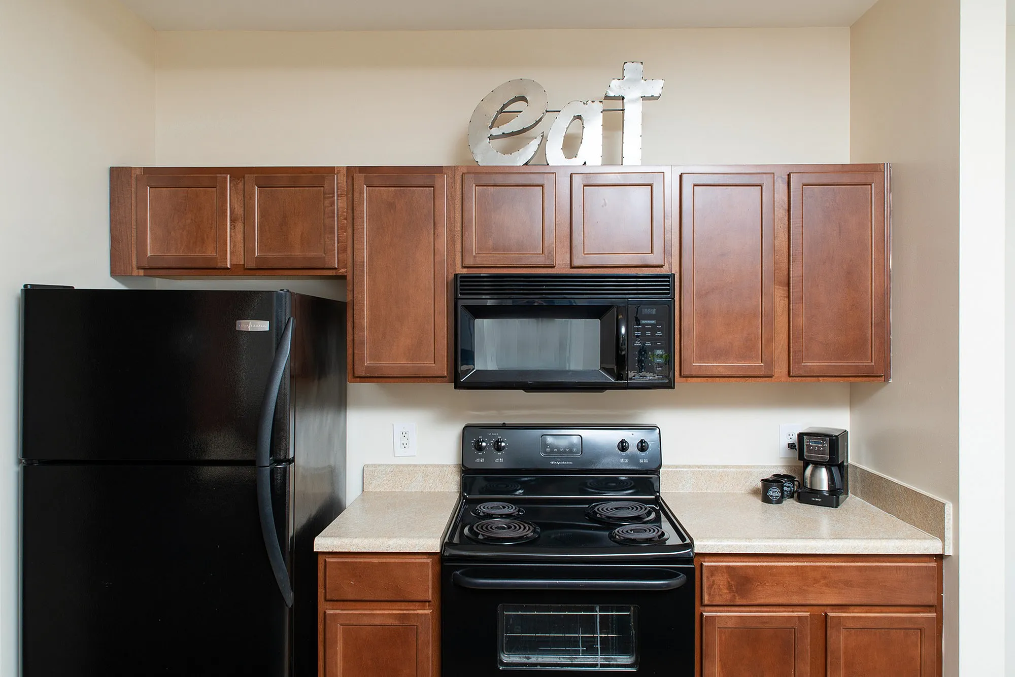 Modern kitchen with sleek black appliances, stylish wooden cabinets, and ample counter space.