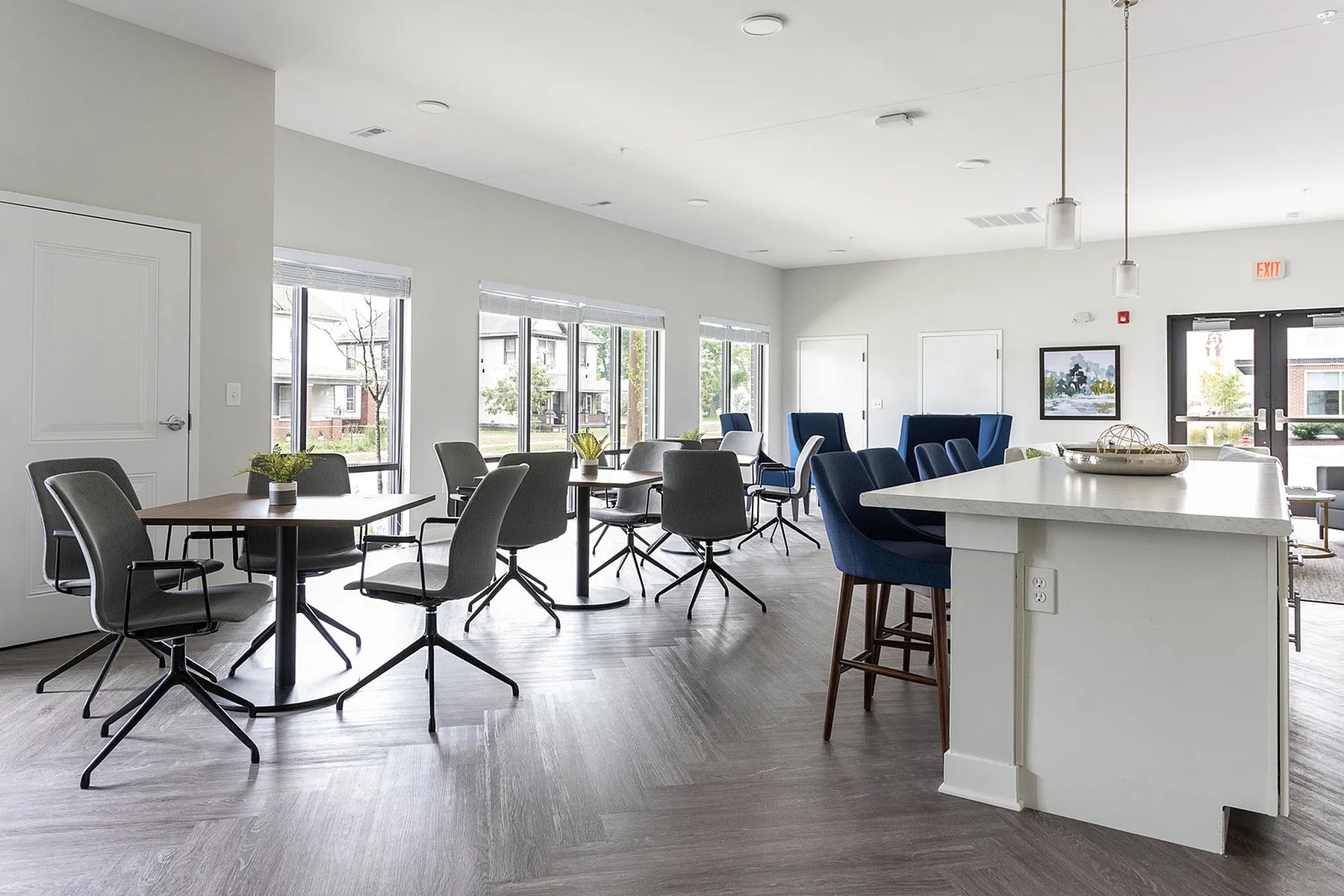 Inviting contemporary communal space with elegant seating, stylish tables, and abundant natural light from large windows.