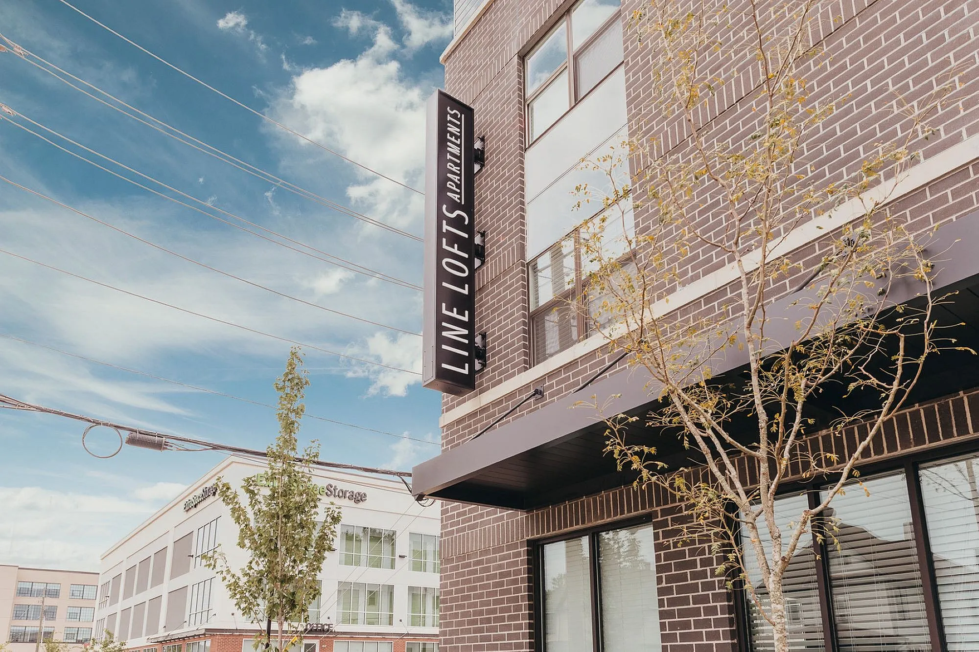 Chic urban apartment exterior with modern brick design at Line Lofts, set against a vibrant blue sky.