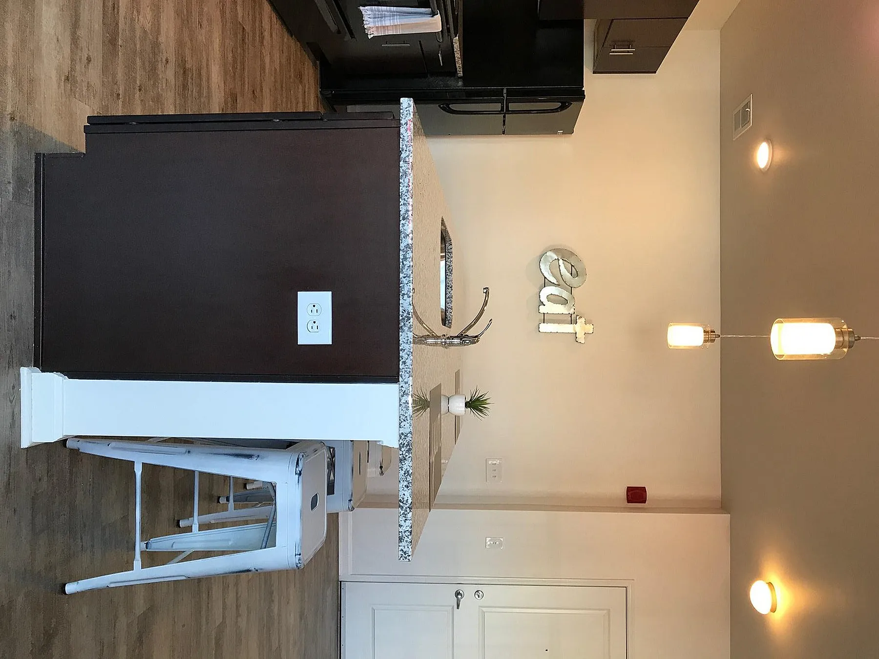 Modern kitchen with elegant countertops, sleek dark cabinetry, and ambient pendant lighting creating a welcoming atmosphere.