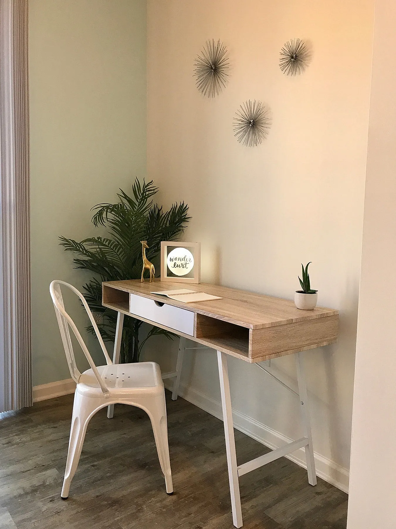 Chic home office nook with a sleek wooden desk, modern metal chair, and vibrant green plant for a refreshing ambiance.