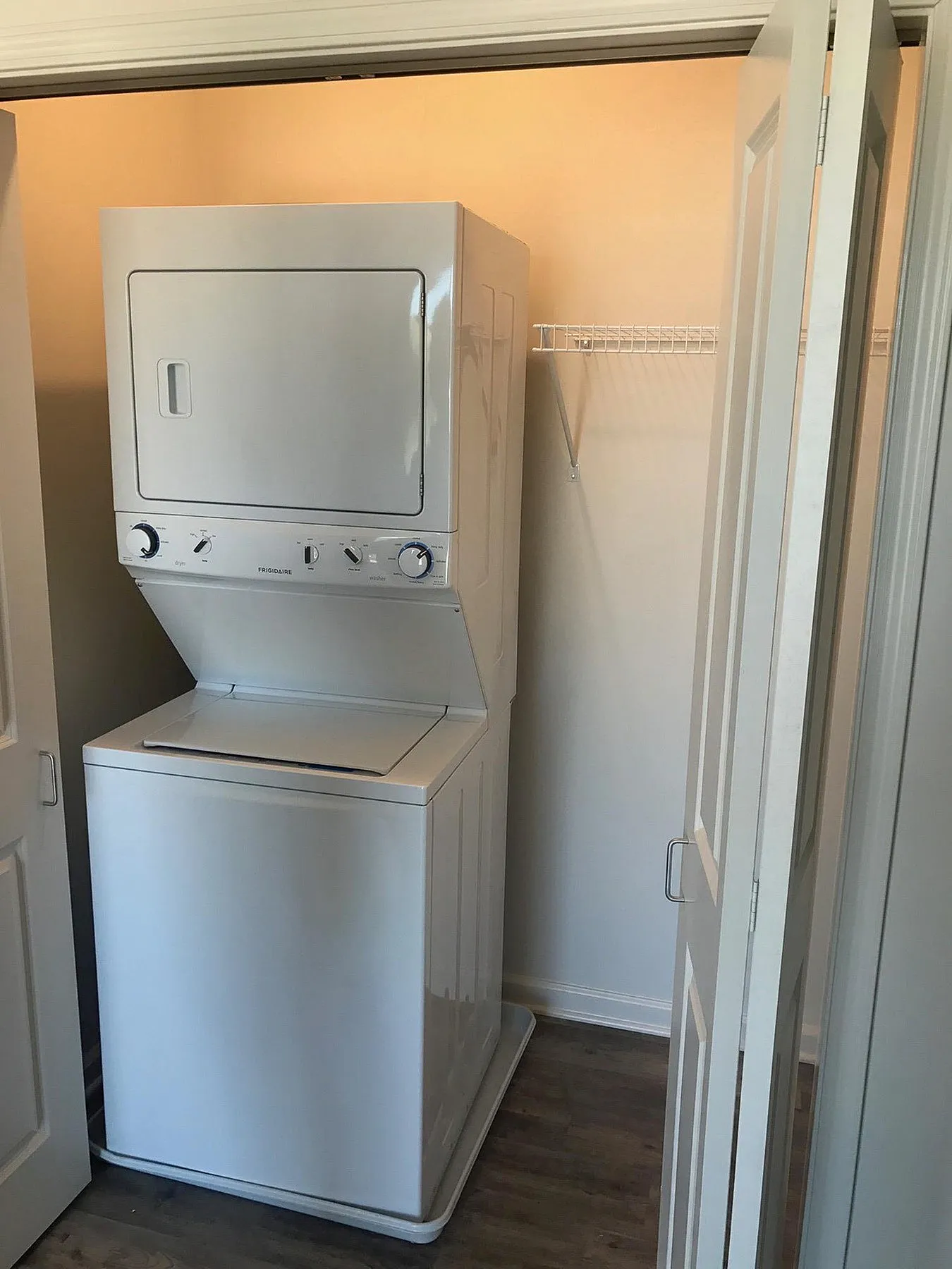 Convenient in-unit laundry with modern stacked washer and dryer in a sleek closet space.