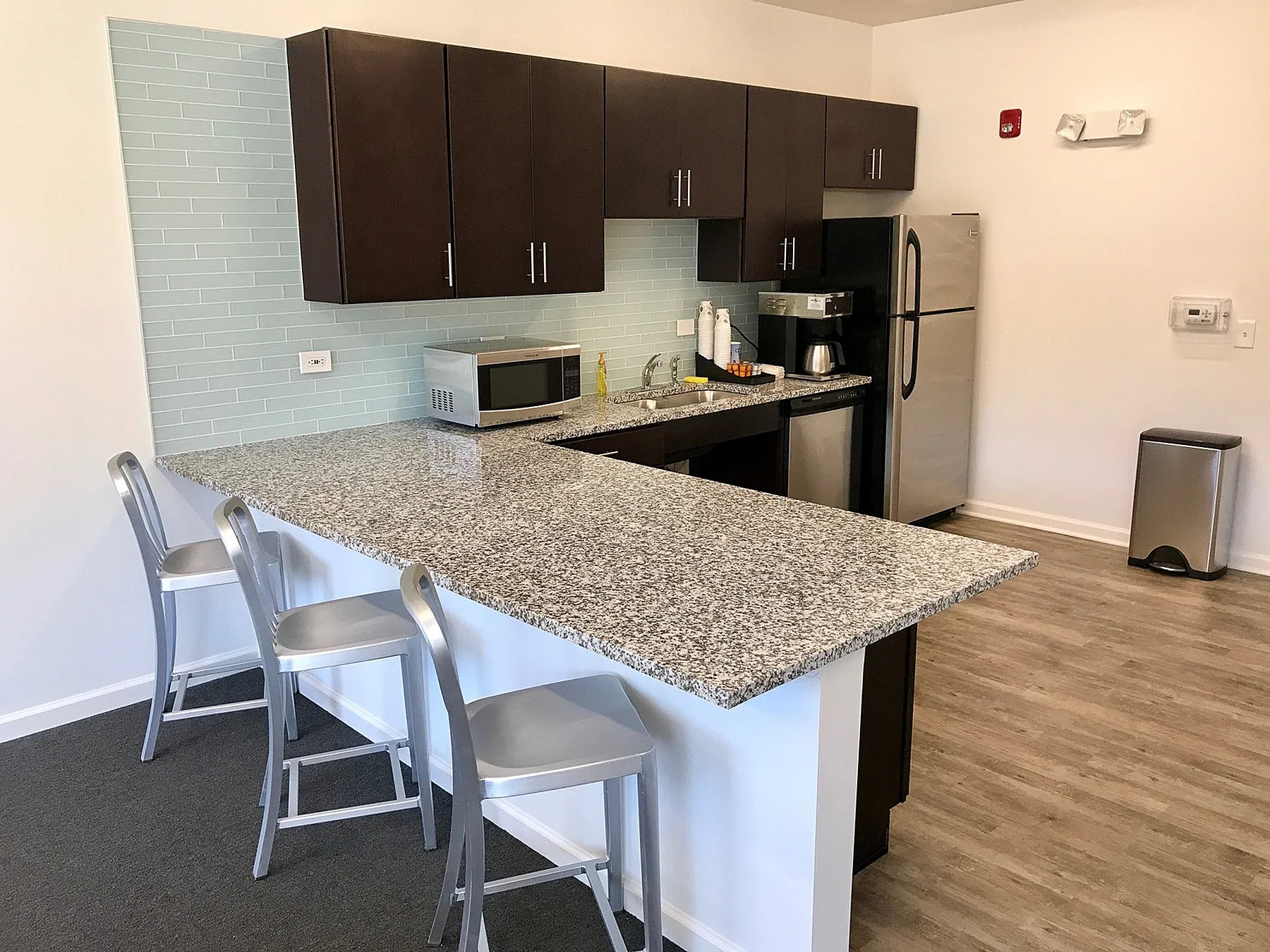Modern kitchen with sleek granite countertops, stylish cabinets, and stainless steel appliances, featuring an inviting breakfast bar with elegant barstools.