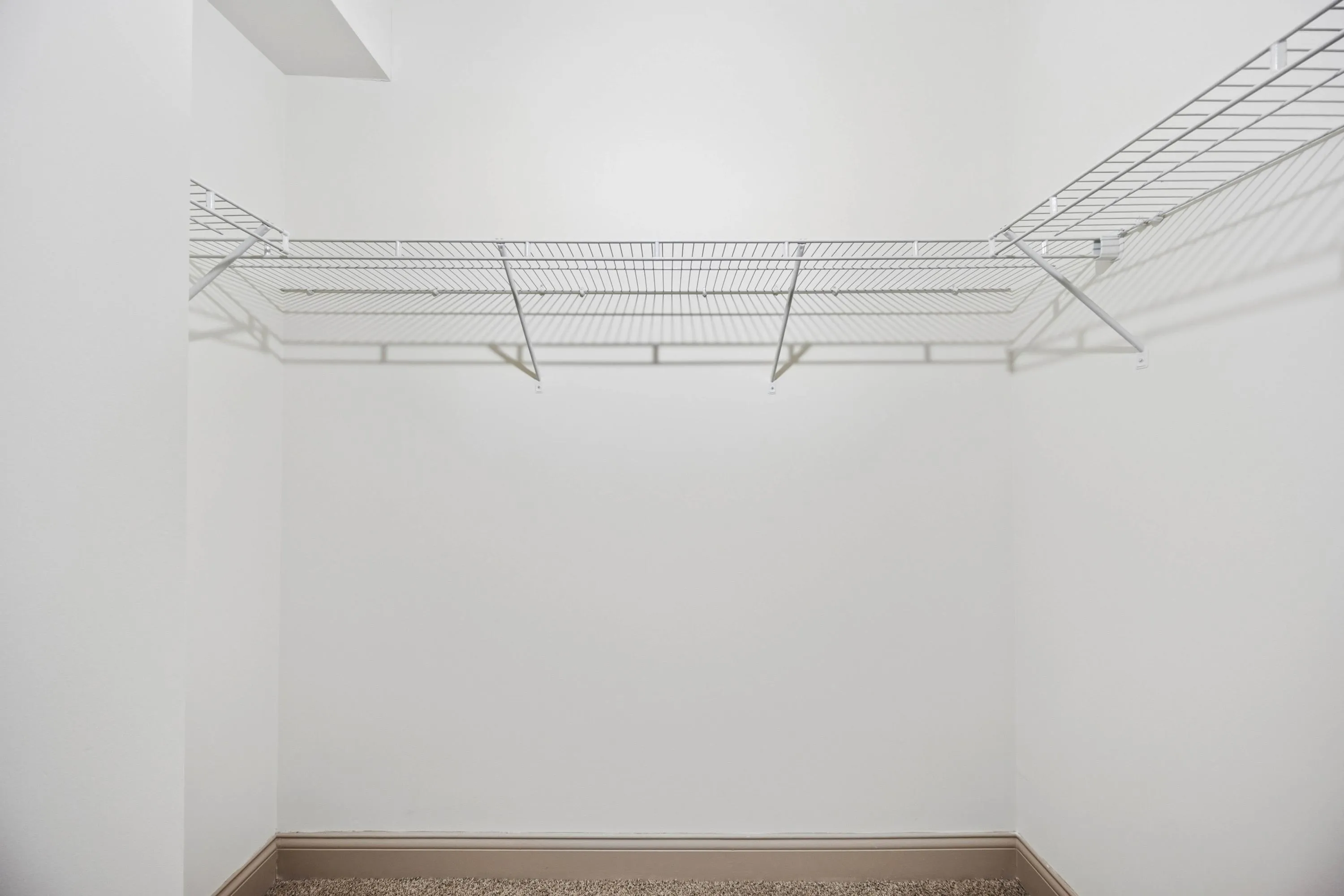 Spacious walk-in closet with sleek wire shelving, perfect for organized and stylish storage solutions.