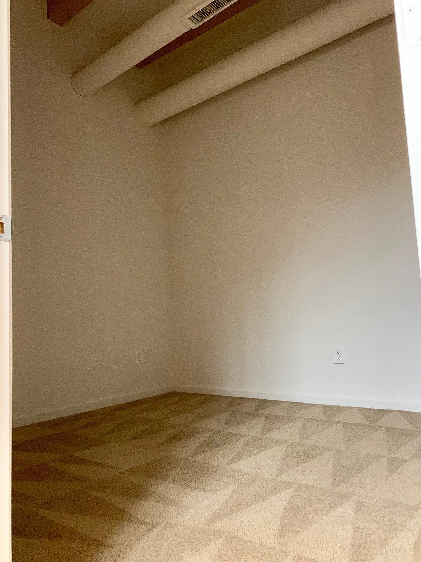 Cozy room with elegant patterned carpet and high ceilings, offering a warm and inviting space.