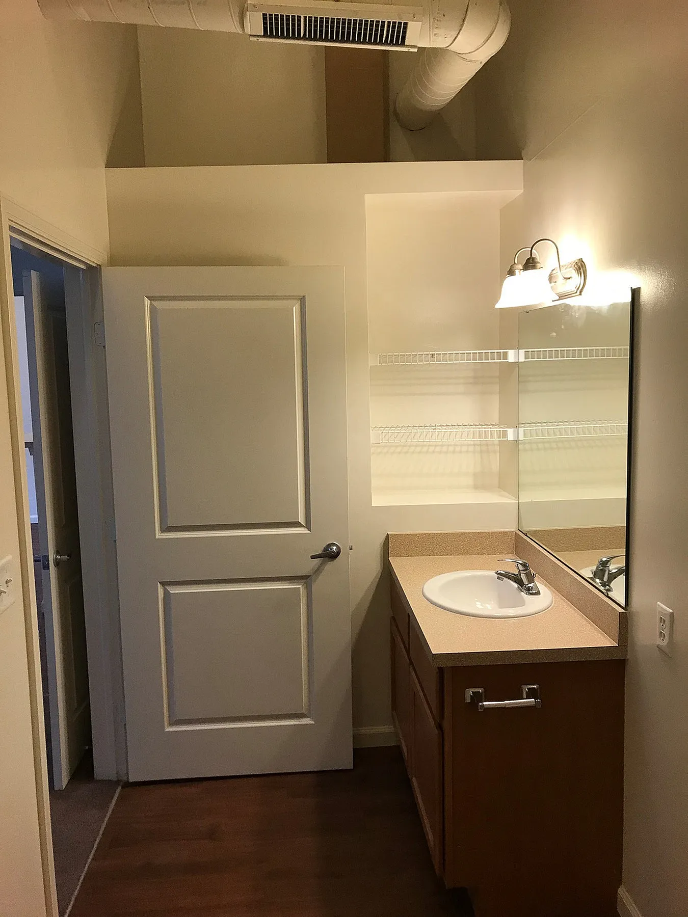 Contemporary bathroom featuring elegant lighting, spacious mirror, and a stylish vanity with ample storage.