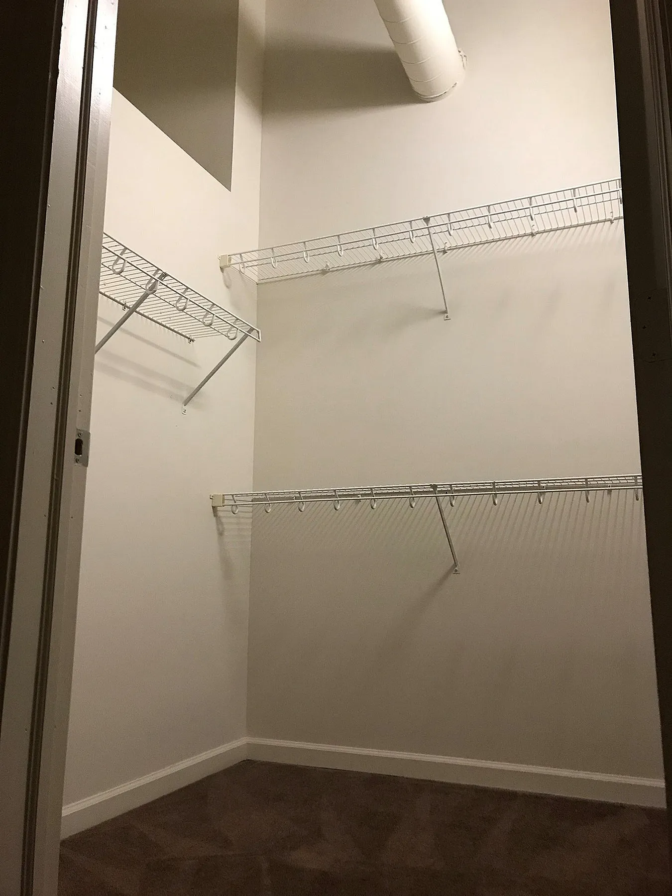 Spacious walk-in closet with ample shelving and modern design, ideal for maximizing storage.