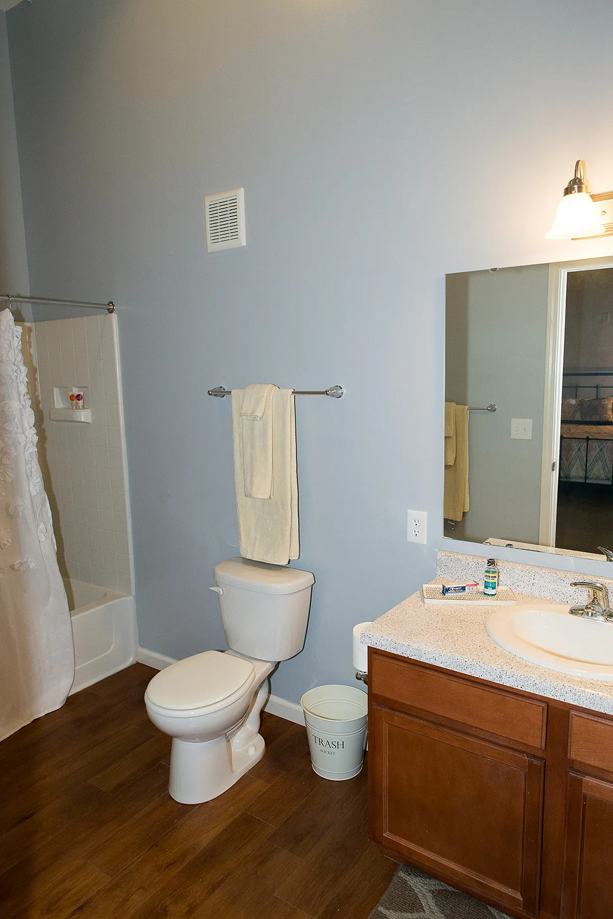 Modern bathroom with elegant wood flooring, stylish vanity, and sleek fixtures, offering comfort and functionality.