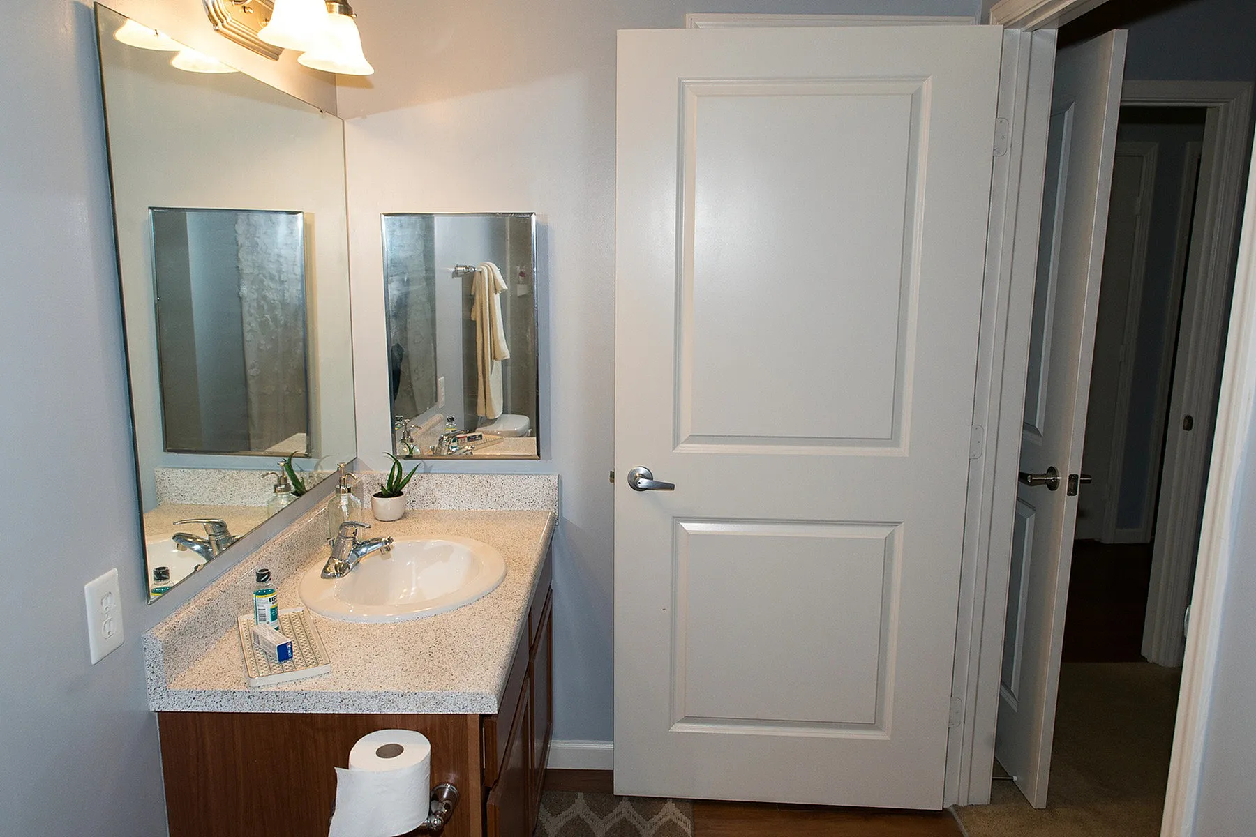 Elegant bathroom with a modern vanity, large mirror, and warm ambient lighting, showcasing contemporary living.