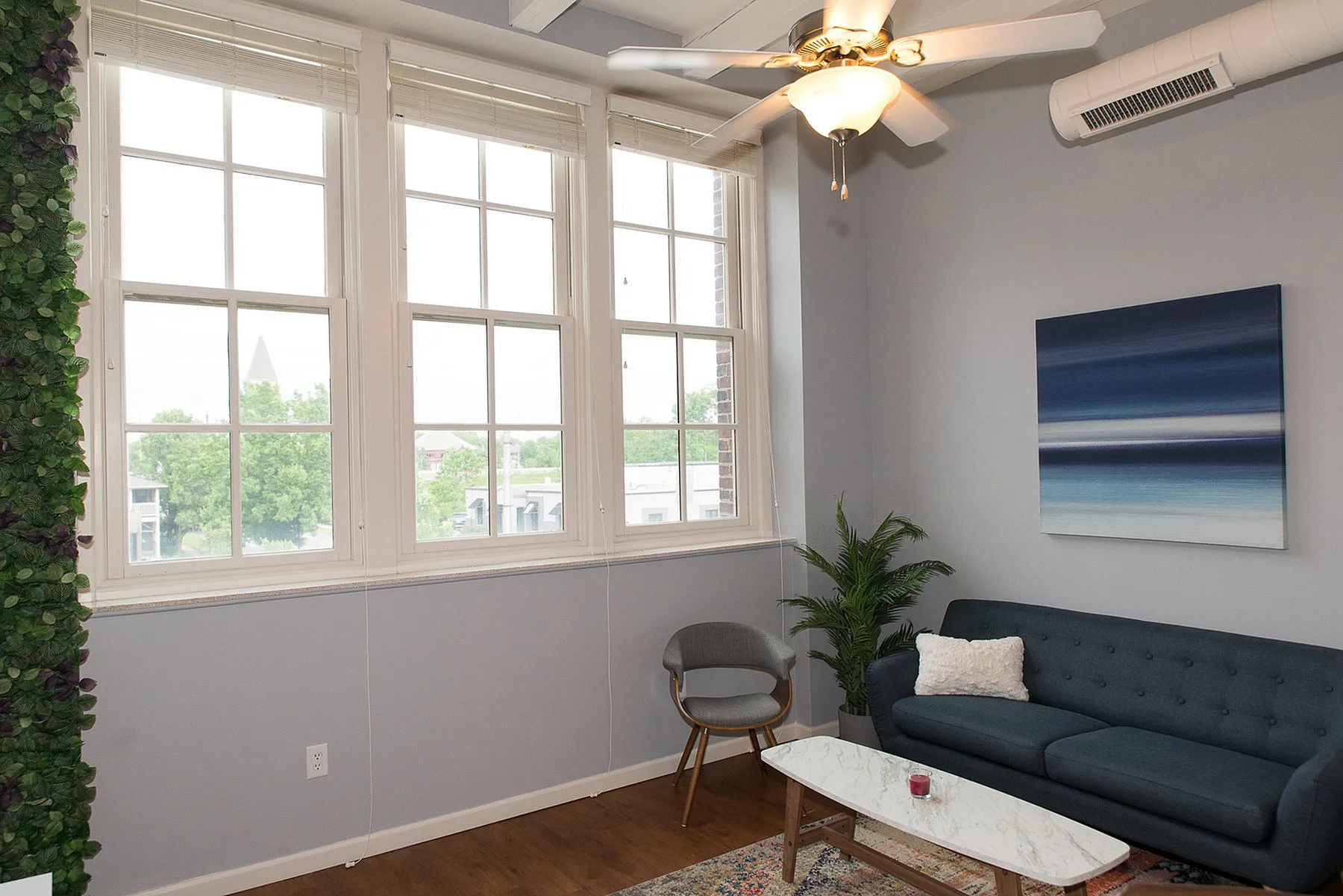 Bright and inviting living room with large windows, modern sofa, and elegant decor, perfect for relaxation.