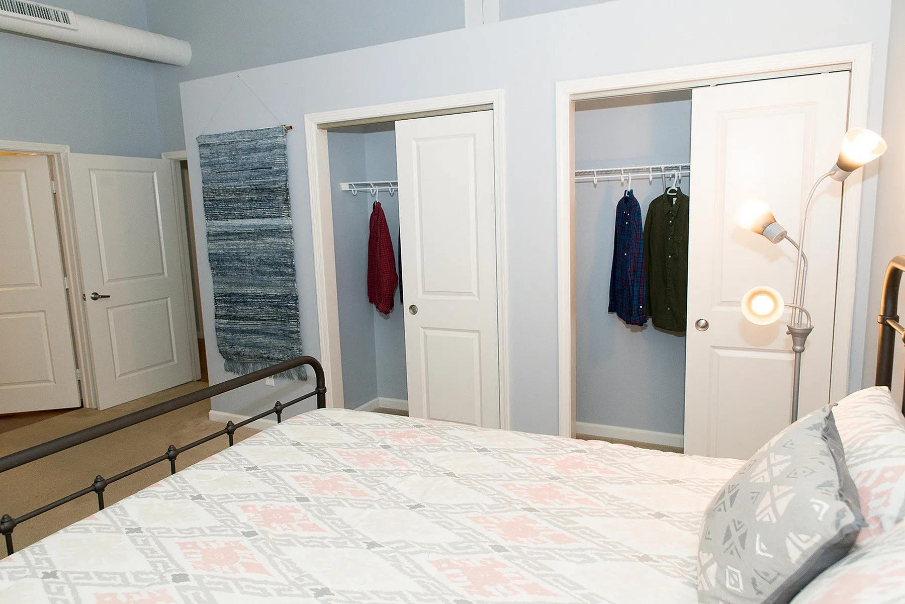Chic bedroom with dual closets, modern lighting, and stylish decor creating a cozy ambiance.