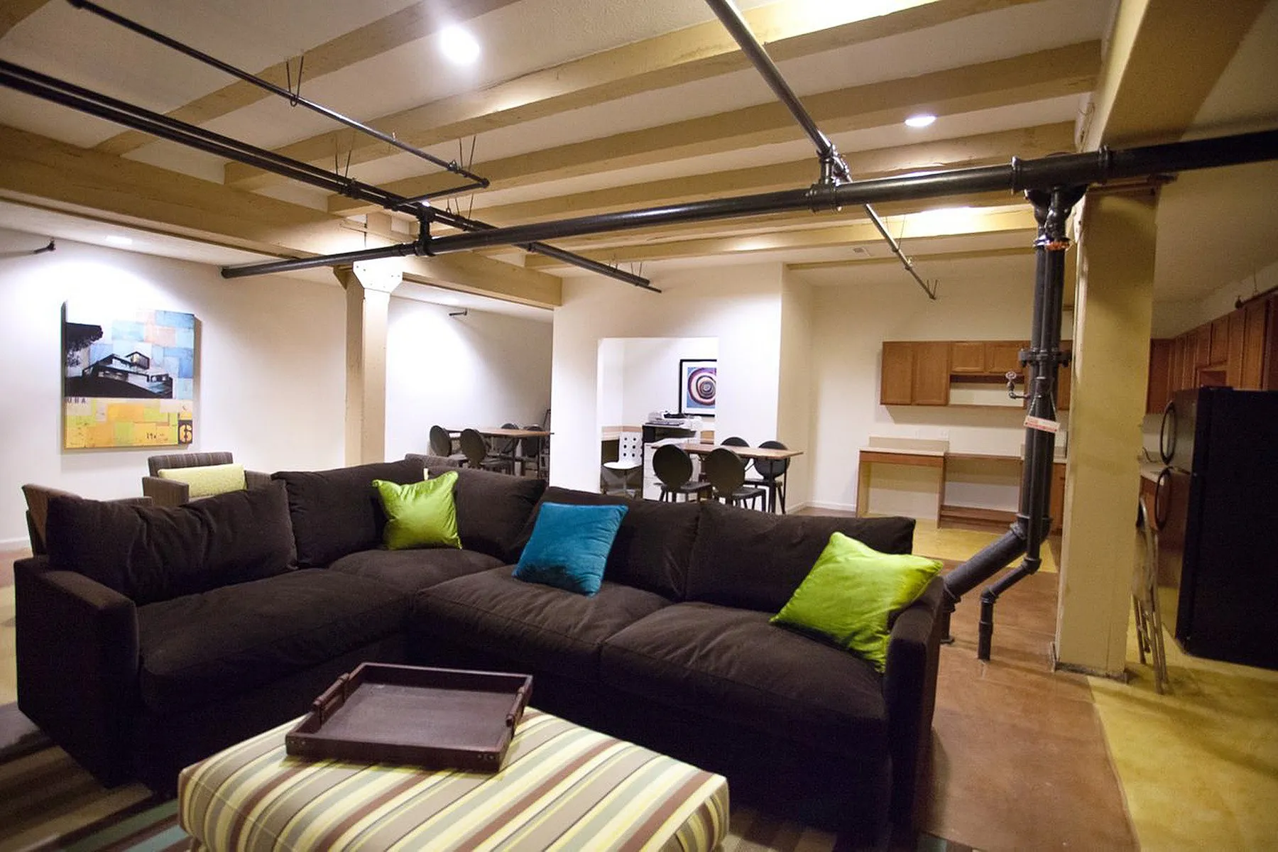Inviting open-concept living area with plush sectional sofa, vibrant cushions, and stylish modern decor, perfect for relaxation and entertainment.