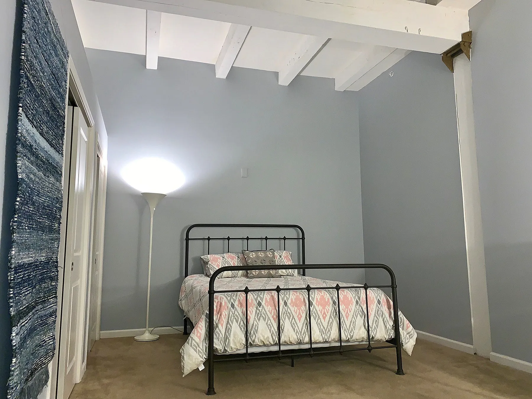 Inviting bedroom with warm lighting, featuring a cozy bed and stylish decor in a modern apartment.