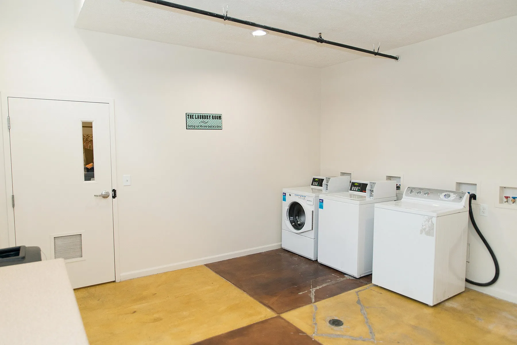 Bright and modern communal laundry room featuring sleek washing machines and ample space for convenience.
