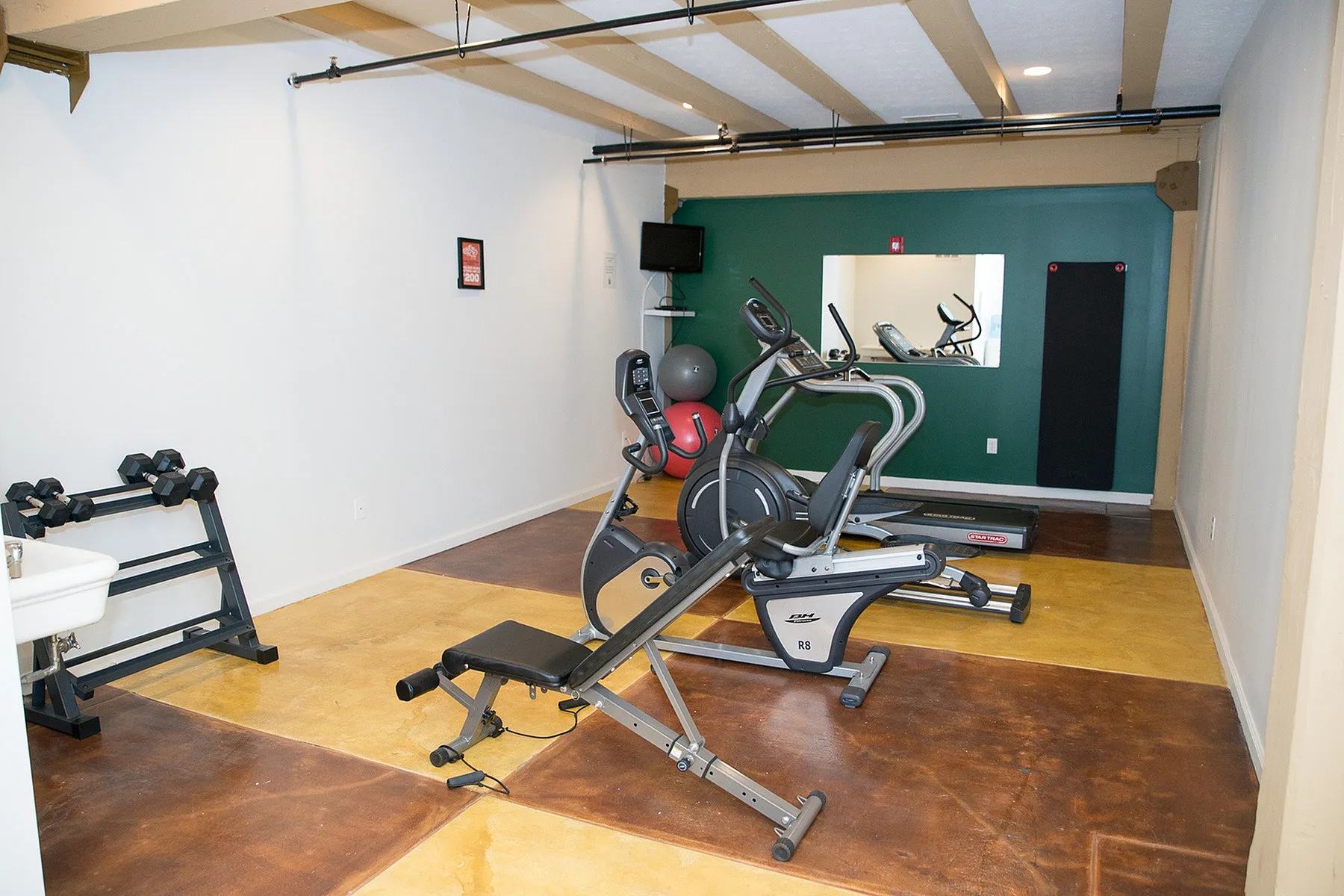 Modern fitness room equipped with state-of-the-art exercise machines and weights, ideal for a healthy lifestyle.